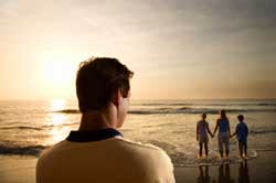 Man looking at mother and children from a far at the beach