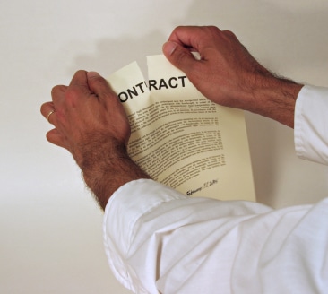 Close-up of a man while ripping a Pre-Nuptial Agreement in half
