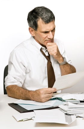 Man looking over paperwork related to debt from divorce